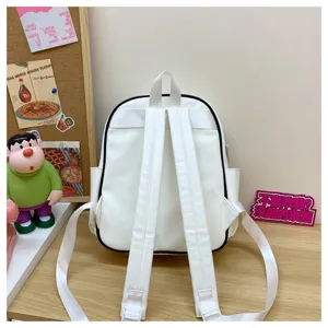 Vue détaillée des bretelles de sac à dos en PU blanc et lignes nettes sur bureau en bois.