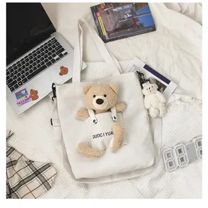 Bonito bolso de lona estilo japonés con bolsillo de oso de peluche y correa ajustable.