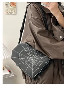Gothic spider web crossbody bag detail showing black leather and white stitching design.