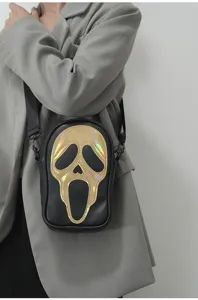 Gros plan d'un sac bandoulière noir tendance doté d'un design de visage de fantôme laser brillant.