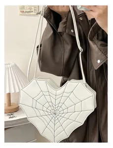 Detail shot of gothic heart crossbody bag featuring unique white spiderweb design and stylish strap.