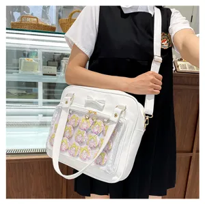 Detail view of white ita shoulder bag with cute bow and clear pocket showing anime badges.