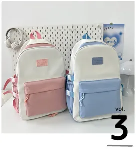 Detailed view of stylish color-blocked casual backpacks in pink and blue on white desk.