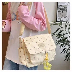 Cute floral canvas messenger bag for teen girls, large capacity crossbody school bag with charm.