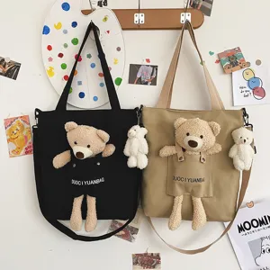 Vista detallada del bolso de lona japonés lindo con osito de peluche y colgante decorativo.