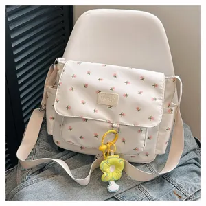White floral canvas messenger bag detail, sweet style with yellow flower pendant and strap.