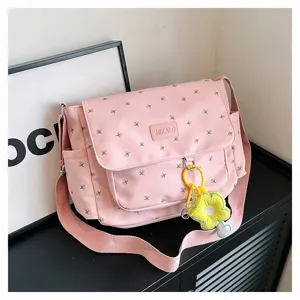 Pink floral canvas messenger bag detail showcasing cute yellow flower pendant and flap.