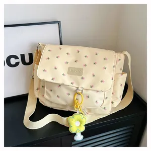 Detailed view of sweet floral canvas messenger bag with cute flower pendant, casual style.