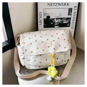 Floral canvas messenger bag detail with flap pocket, leather tag and cute yellow flower pendant.