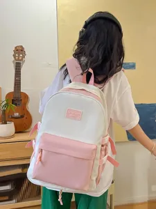 Pink and white canvas student backpack with front pocket and adjustable straps for daily use.