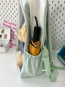 Japanese style cute transparent ita-bag backpack with plush doll and side umbrella pocket detail.