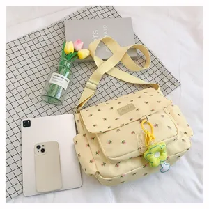 Yellow floral canvas messenger bag with front flap, multiple pockets and a cute charm.