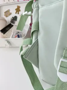 Light green student backpack strap detail view, fashion daily casual school bag chic style.