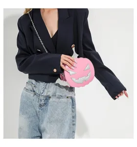 Details of the pink pumpkin cross-body bag featuring silver Halloween face and bat wings.