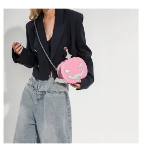 Pink Halloween pumpkin crossbody bag featuring silver chain strap and cute bat wings detail.