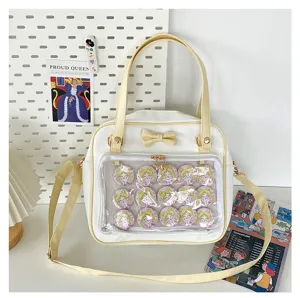 Cute white ita bag with clear window, bow and anime character badges for daily use.