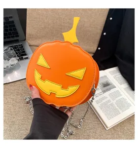 Close-up detail of the Halloween pumpkin crossbody bag in orange with cute spooky face and chain strap.