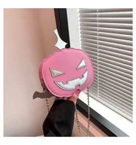 Detail shot of the pink Halloween pumpkin crossbody bag with silver chain and cute face design.