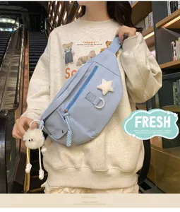 Vue détaillée d'un sac de poitrine en nylon bleu clair, sac banane croisé avec joli pendentif.