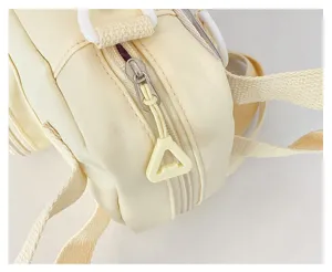 Detail view of a light yellow canvas crossbody small bag, featuring a smooth zipper and straps.