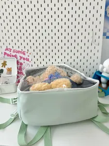Detailed view of the clear window ita bag showcasing a cute plush doll inside on a clean desk.