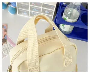 Cute yellow canvas mini bag detail shot, featuring dual top handles and zipper closure design.
