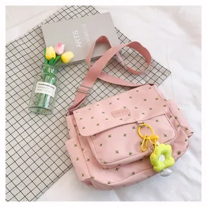 Pink floral canvas messenger bag with adjustable strap and cute flower pendant, detailed shoulder bag.