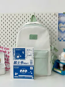 Backpack detail view showing mint green and white color scheme and functional pockets.