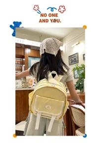 Detailed shot of a cute yellow mini canvas backpack with white flap pocket and straps.