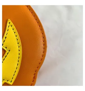 Close-up detail of orange and yellow leather color block handbag showcasing fine stitching.