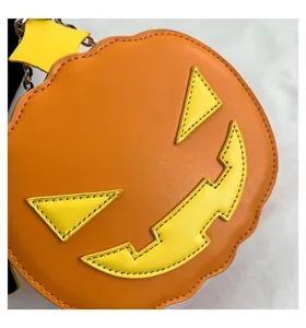 Halloween pumpkin crossbody bag detail close up showing orange leather texture yellow stitching.