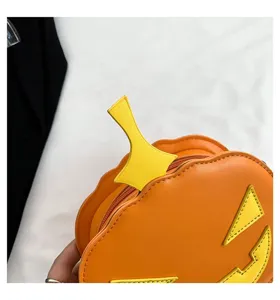 Detail view of the orange pumpkin crossbody bag featuring yellow facial features and PU leather.