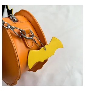 Detailed view of Halloween orange pumpkin leather shoulder bag with cute bat charm.