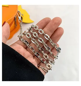 Halloween pumpkin shoulder bag metal chain strap detail, stylish and creative accessory.