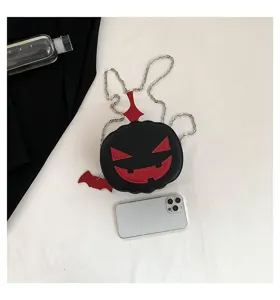 Close-up detail of the creative Halloween pumpkin cross-body bag with red contrast facial features.