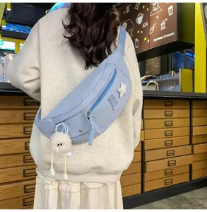 Vue détaillée du sac de poitrine en nylon bleu clair avec pendentif en peluche et étoile au café.