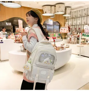 Detailed lifestyle view of the cute white ita backpack worn by model in a cozy store.