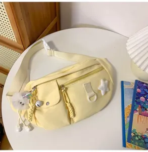 Gros plan détaillé du sac de poitrine en nylon jaune décontracté avec des poches et breloque.