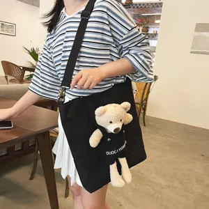 Bolso cruzado negro de lona para mujer con bolsillo de peluche de oso, bolso casual diario.