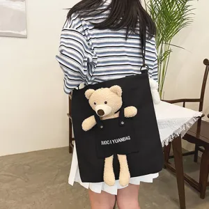 Bolso de lona negro para mujer, con un adorable oso de peluche y un práctico bolsillo frontal.