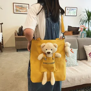 Bolso bandolera de lona para mujer con osito de peluche juguetón, ideal para el uso diario.