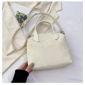 Stijlvolle witte dameshandtas met handvat en verstelbare schouderband voor dagelijks gebruik.