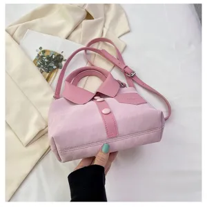 Detail van de roze overhemdtas met unieke kraag en knopen voor stijlvolle en moderne vrouwen.