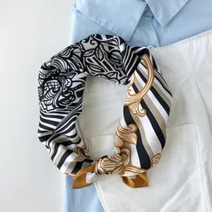 Elegantes seidenes Halstuch mit schwarz-weißem Muster und goldenen Barock-Streifen.
