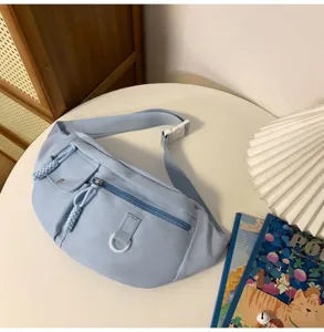 Sac de poitrine en nylon bleu clair pour femme, élégant sac bandoulière avec poches zippées.