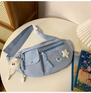 Vue détaillée de sac de poitrine en nylon bleu clair, sac bandoulière tendance avec charm pelucheux.