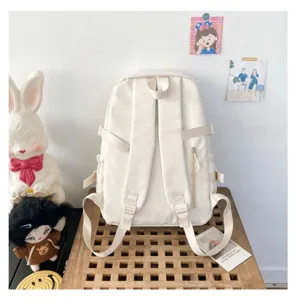 Detail view of the casual white canvas backpack showcasing back straps and pocket structure.