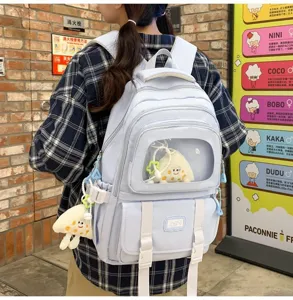 Detailed view of light blue campus backpack with clear window and cute plush toy charm.