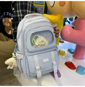 Light blue student backpack with transparent display window and cute plush pendants for daily use.