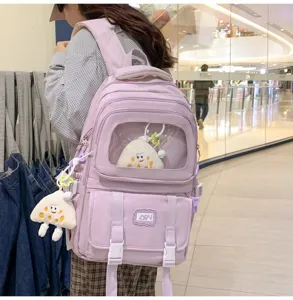 Light purple canvas school backpack with clear window and cute plush pendants for daily campus use.